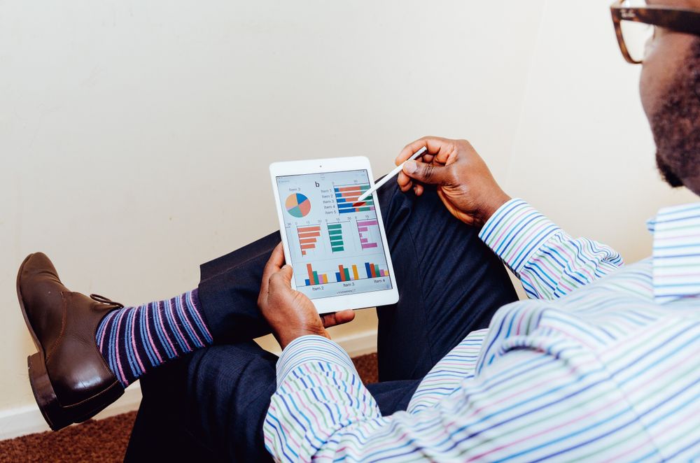 Back view of a business man examining financial statistics on tablet computer