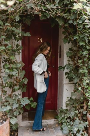 Stylish woman standing near red door