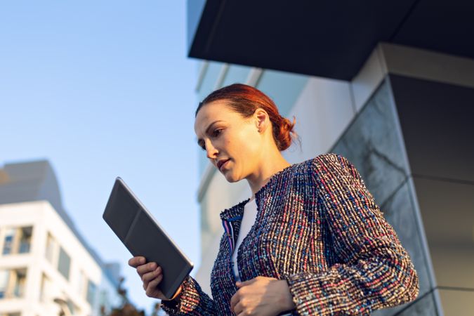 Confident entrepreneur with tablet on city street