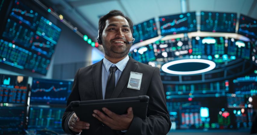 Talented Indian Stock Exchange Investor Working on a Tablet Computer, Day Trading Company Shares, Valuable Technology Investments, Communicating with Clients