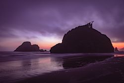 Two large rocks under cloudy purple hued sky