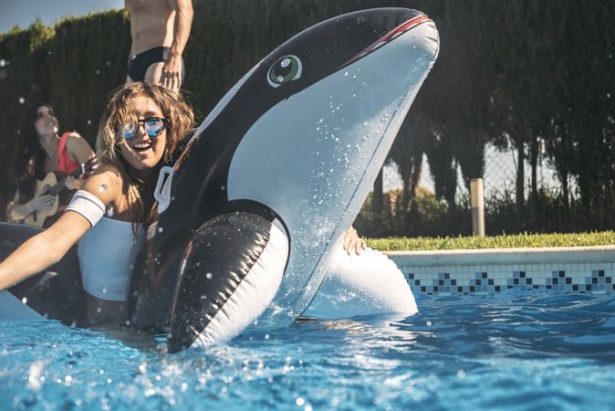Woman floating over an inflatable killer whale