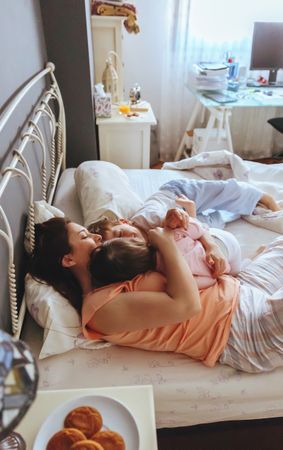Portrait of happy family embracing lying in bed on a relaxed morning