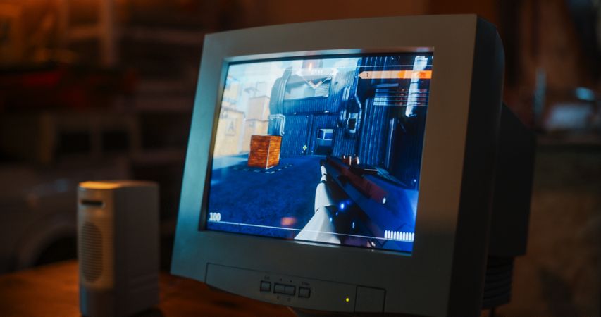 Close Up Of Old Desktop Computer With 3D First-Person Shooter Video Game In Retro Garage Late At Night In Nineties.