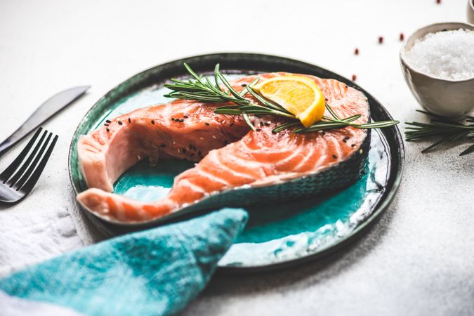 Salmon fish and rosemary on stone background with copy space