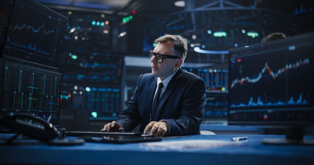 Adult Man in Glasses Looking at Computer Screens, Analyzing Stock Exchange Market Data, Brainstorming a Successful Buying Strategy