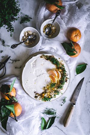 Tangerine cake decorated with whipped cream and sliced citrus