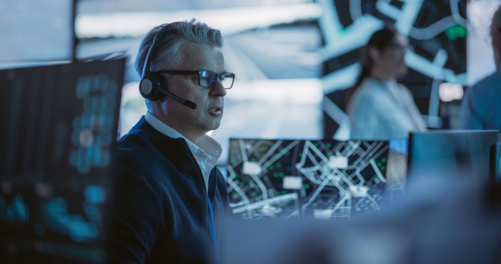 Surveillance Specialist in a Modern Monitoring Room with Displays and Computers.