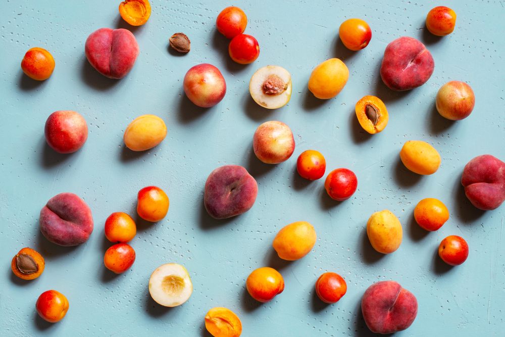Blue table scattered with summery stone fruit
