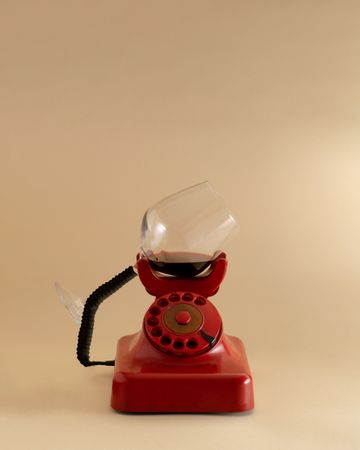 Vintage rotary phone with red wine instead of an ear piece