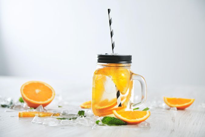 Single glass of orange infused water with straw
