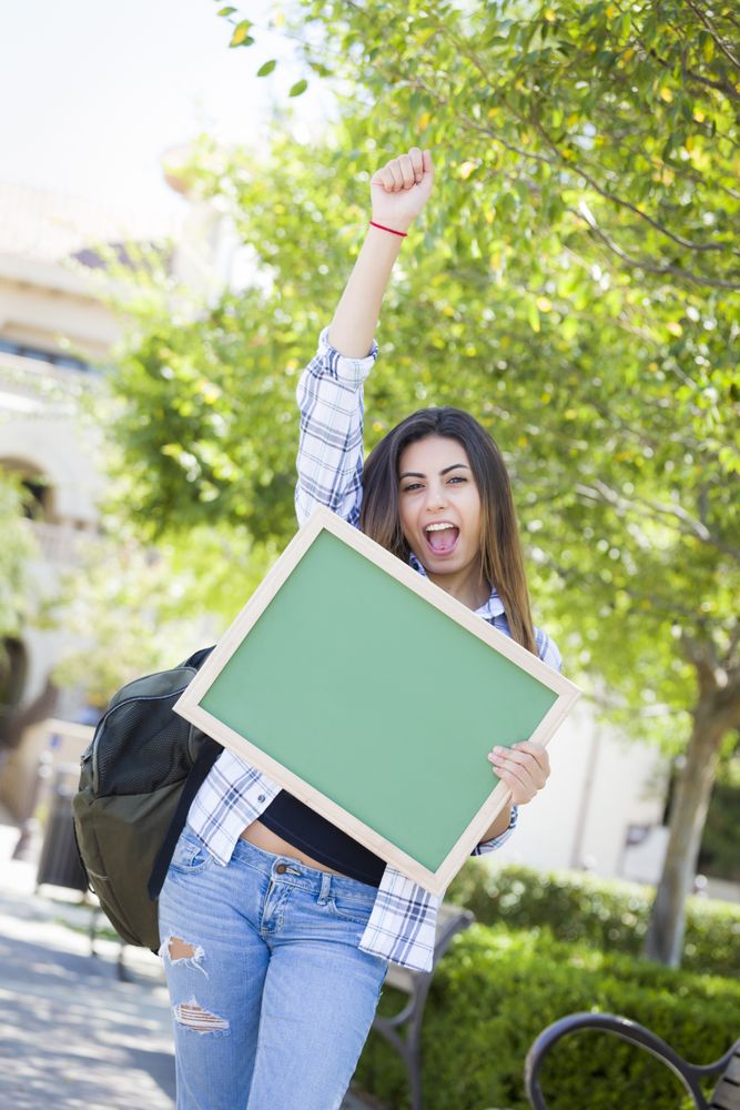 Female Student Holding Blank Chalkboard And Celebrating