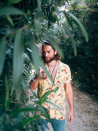 Hipster man in jungle with ukulele