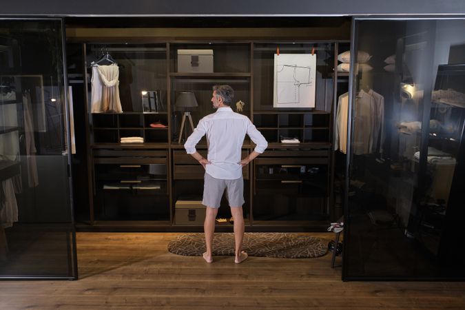 Mature man standing near wardrobe