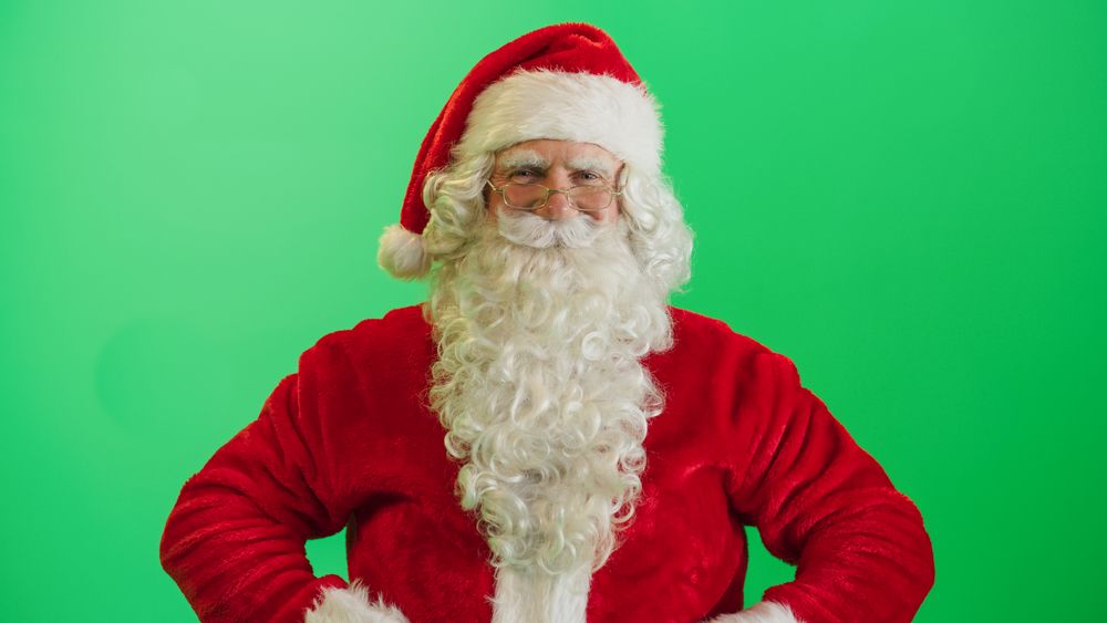 Studio Shot Isolated Mockup Template: Jolly Santa Claus Standing On Green Screen Chromakey Background With Hands Crossed, Looks At The Camera Cheerfully. Christmas, New Year, Celebration