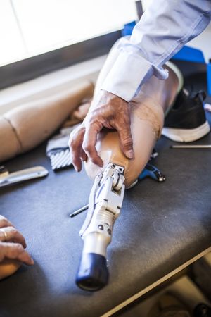 crop man fixing prosthesis in workshop
