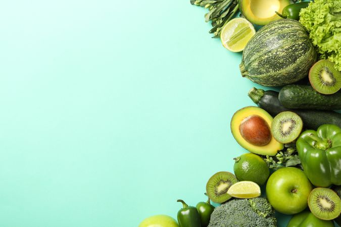 Green vegetables and fruits on mint background