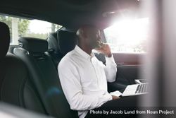 Entrepreneur working during traveling to office in a luxury car 0LNDe4