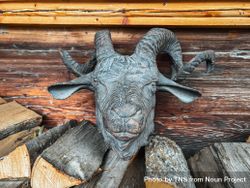 Mountain goat figurehead on pile of logs in Rossiniere, VD 0JGoBp