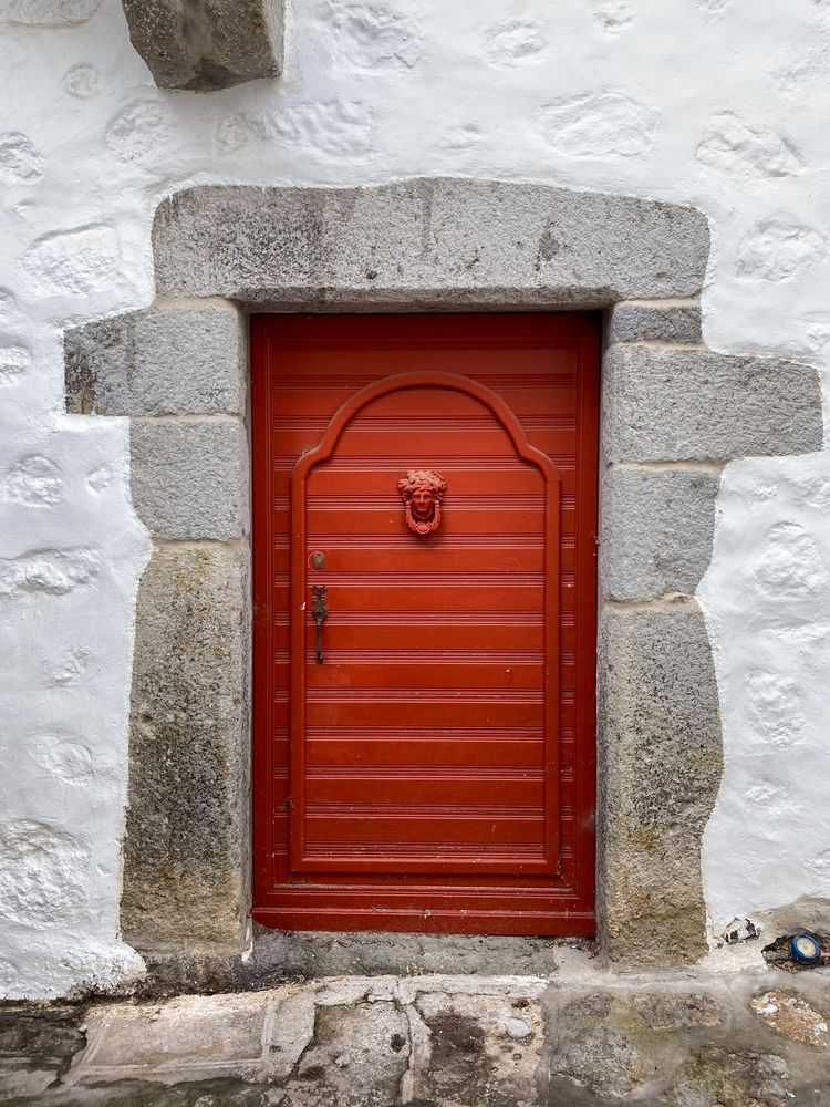 Patmian red door with figurehead knocker