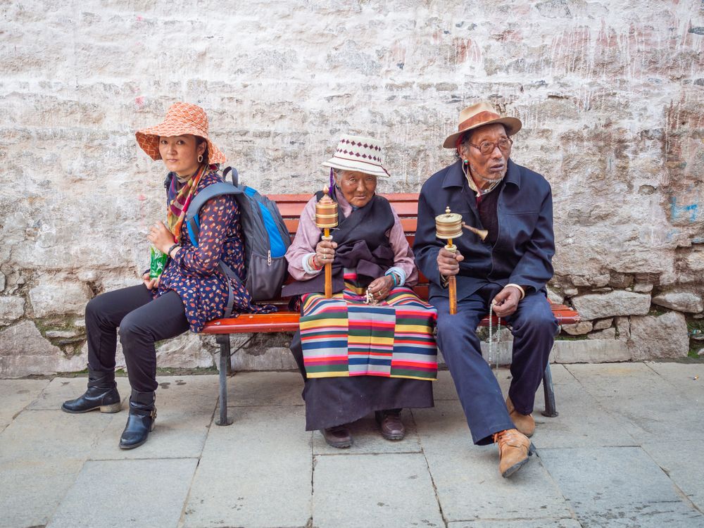 Tibet - August, 29 2014: people sitting on street bench