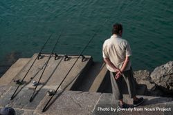 Man  waiting with three fishing lines in the water 5w6By0