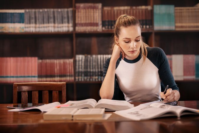 Focused college student preparing for exam in library