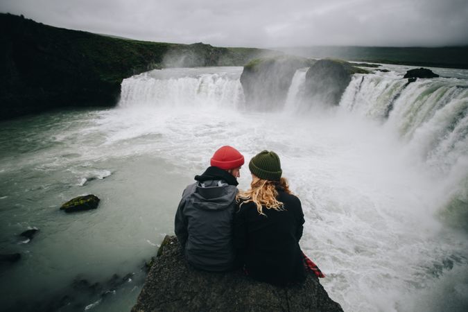 Couple sitting looking at waterfall