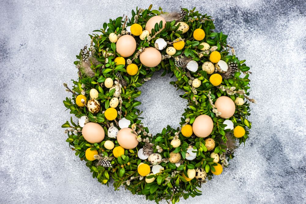 Easter card concept with wreath with eggs and spring flowers