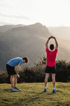 Sportsmen stretching after running in mountains