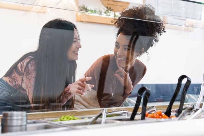 Multiethnic women choosing food in restaurant
