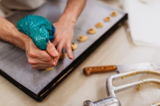 Crop baker squeezing dough on tray