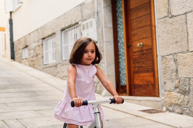 Girl riding on bicycle in narrow street