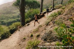 Young couple trail running on a mountain path 0VKdG5