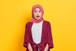 Surprised woman in red headscarf looking at camera