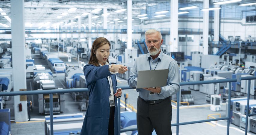 Experienced Mature Engineer Giving an Electronics Factory Tour to Young Japanese Student. Asian Female with Technical Background Asking Questions About Production, Manufacturing, Research