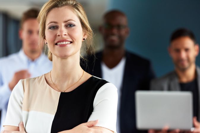 Close up of smiling businesswoman in front of her colleagues