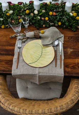 Festive table setting for Easter holiday dinner decorated with flowers and eggs