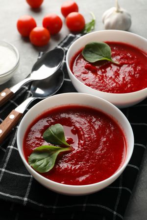 Tomato soup bowls on kitchen towel, vertical