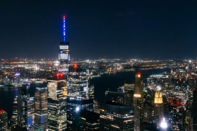 Night Aerial Shot of the One World Trade Center Skyscraper with Antenna. Helicopter Photo of a Group of Glass Buildings in Manhattan