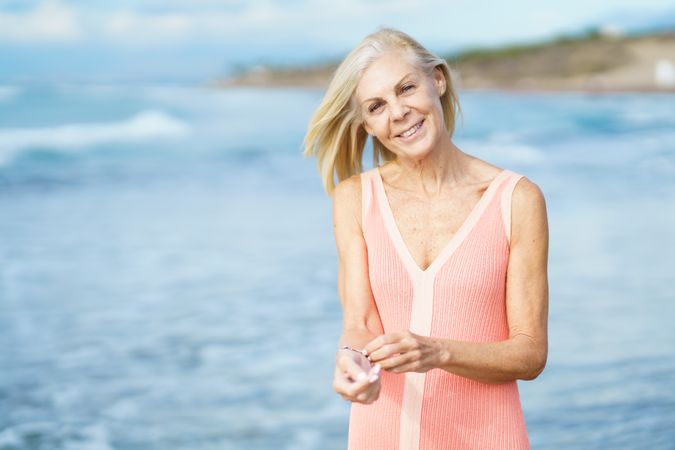 Calm smiling older woman standing near coast