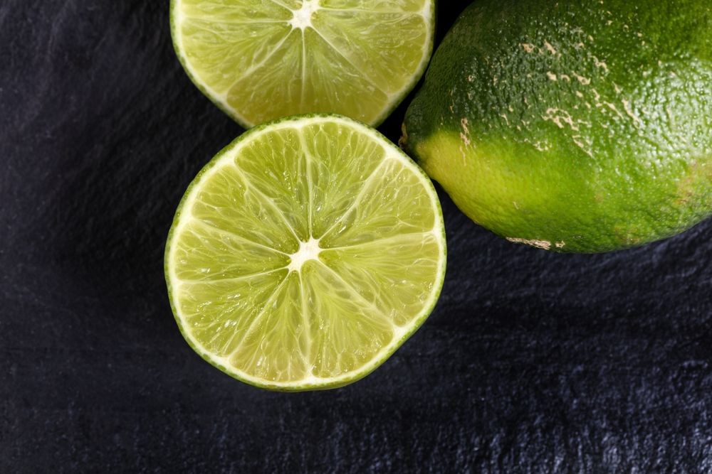 Freshly sliced organic limes on slate background