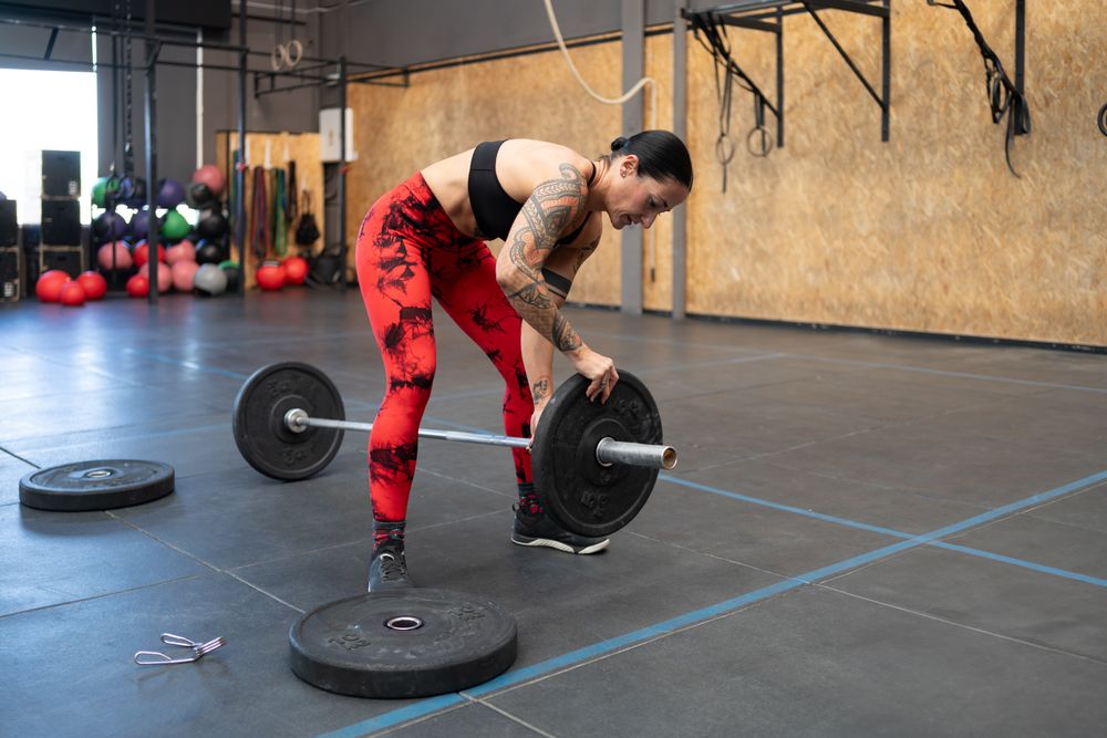 Woman putting weight on bar in gym