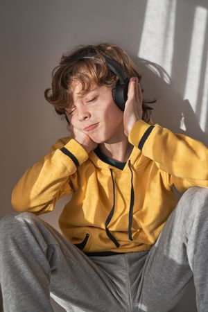 Boy with closed eyes enjoying music at home