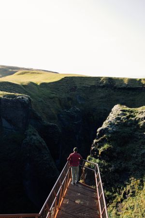 Man on walkway over epic landscape