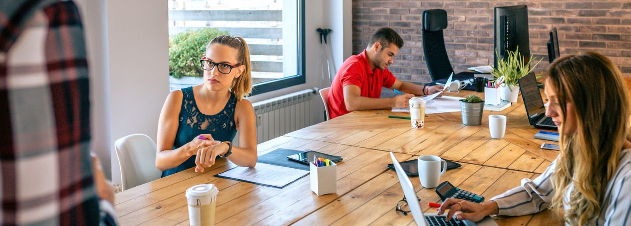 Angry female manager discussing with man for coming late to office