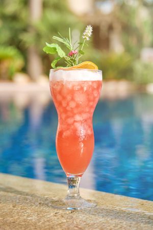 Glass of cocktail on poolside in summer resort