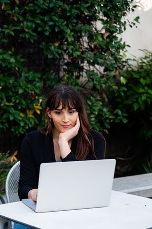 Transgender woman sitting at laptop outside