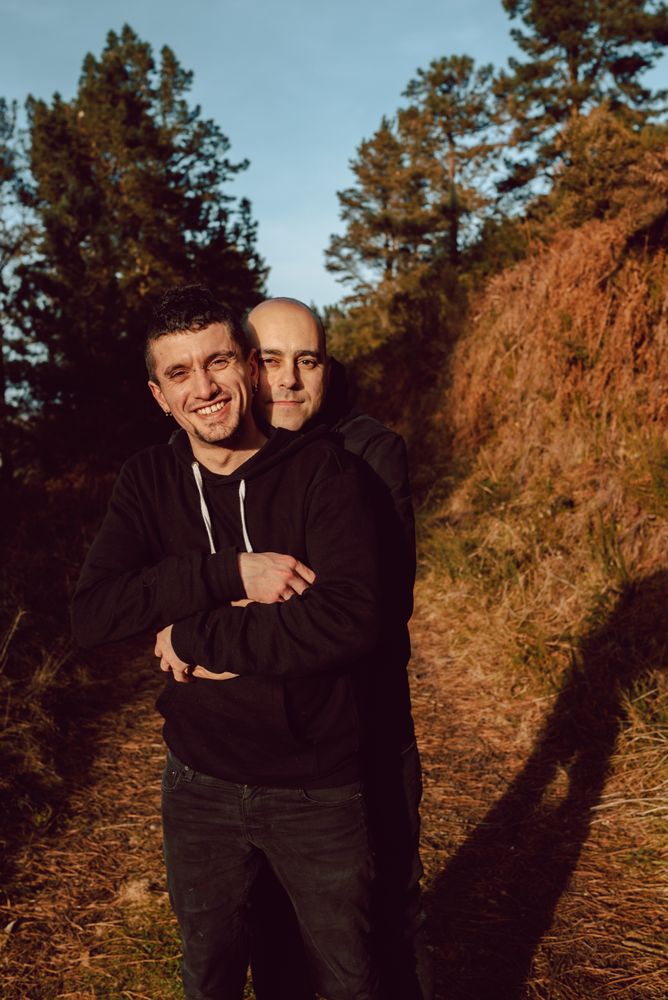 Smiling men hugging on path in park