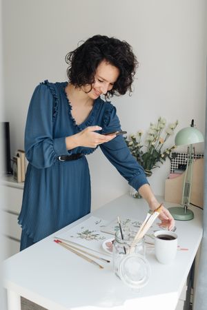 Artist photographing drawings with smartphone